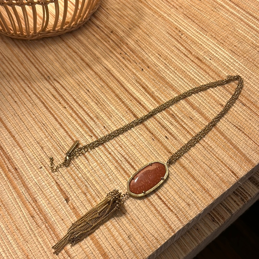 Kendra Scott long gold necklace with sparkly burnt orange stone